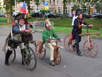 833595 Afbeelding van drie gekostumeerde heren op loopfietsen, bij de start van 'La Caravane d'Utrecht' in het ...